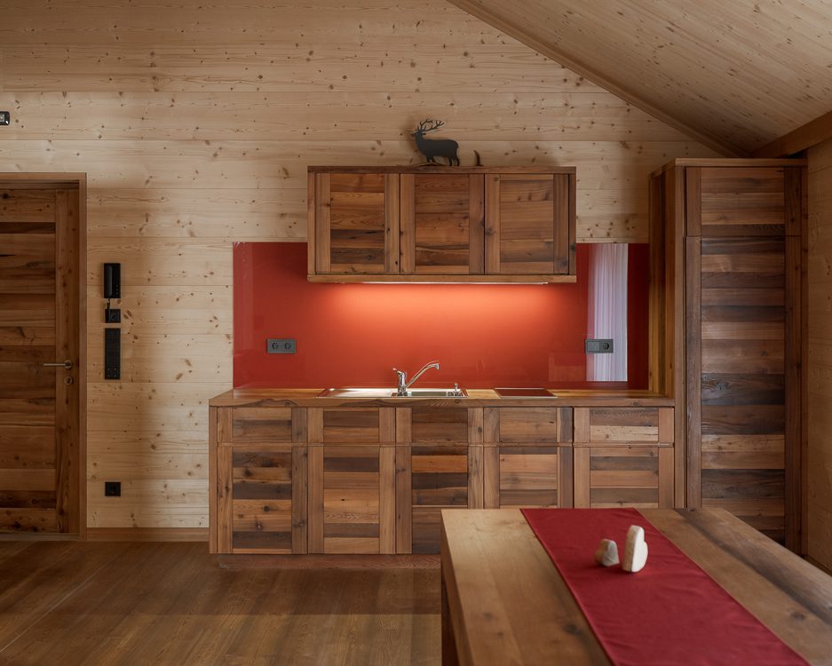 Küchenzeile aus Holz mit Waschbecken, Kühlschrank und Herdplatten